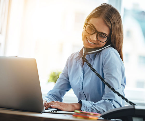 Woman on the phone in front of computer